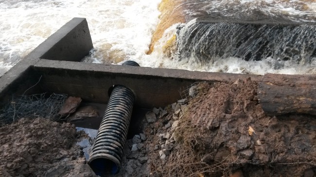 The pipe that now blocks the hole in the wall of the fish pass.There's a fair bit of very dirty water in there I'm not certain if it coming from the ground or the work. I'm unclear how this pipe will be finished as we have yet to see the detail in a drawing. 