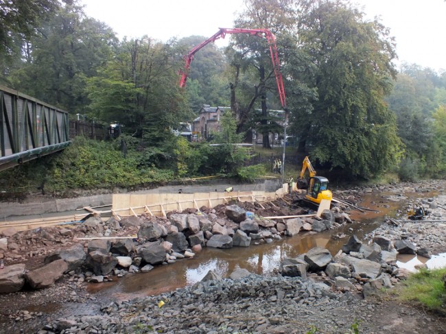 The concrete pumping operation as the last section is completed. The river bed has been scraped and piled behind the shuttering to add strength