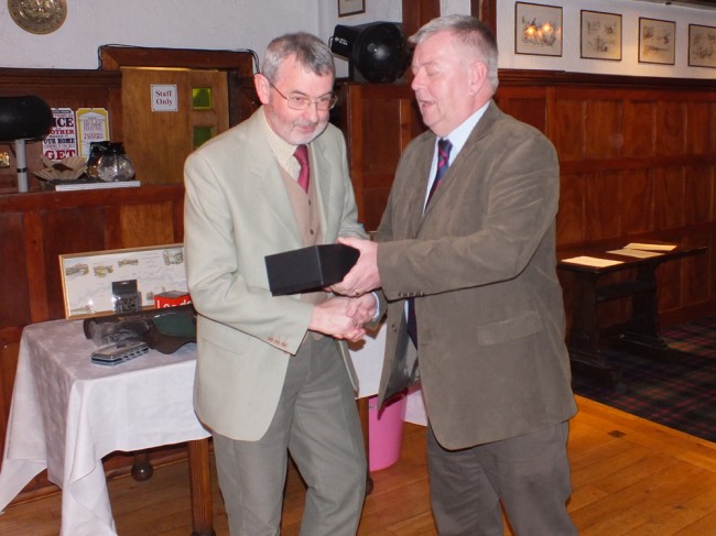 Trust Chairman Bill Stafford presenting Alex Anderson with a pair of whisky glasses at the start of the evening